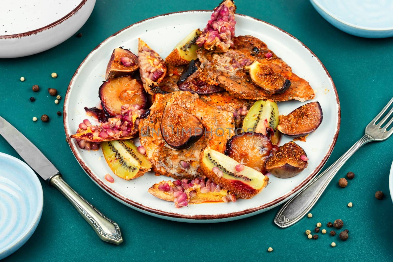 Meat pork steaks roasted with figs, kiwi and pomegranate. Free space for your text.