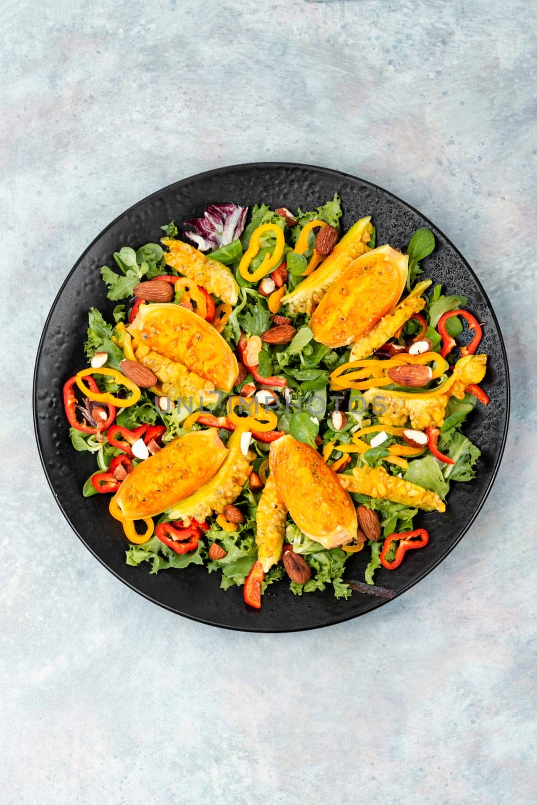 Cactus salad with sliced opuntia or prickly pear, peppers, almonds and fresh herbs, served in plate. Flat lay