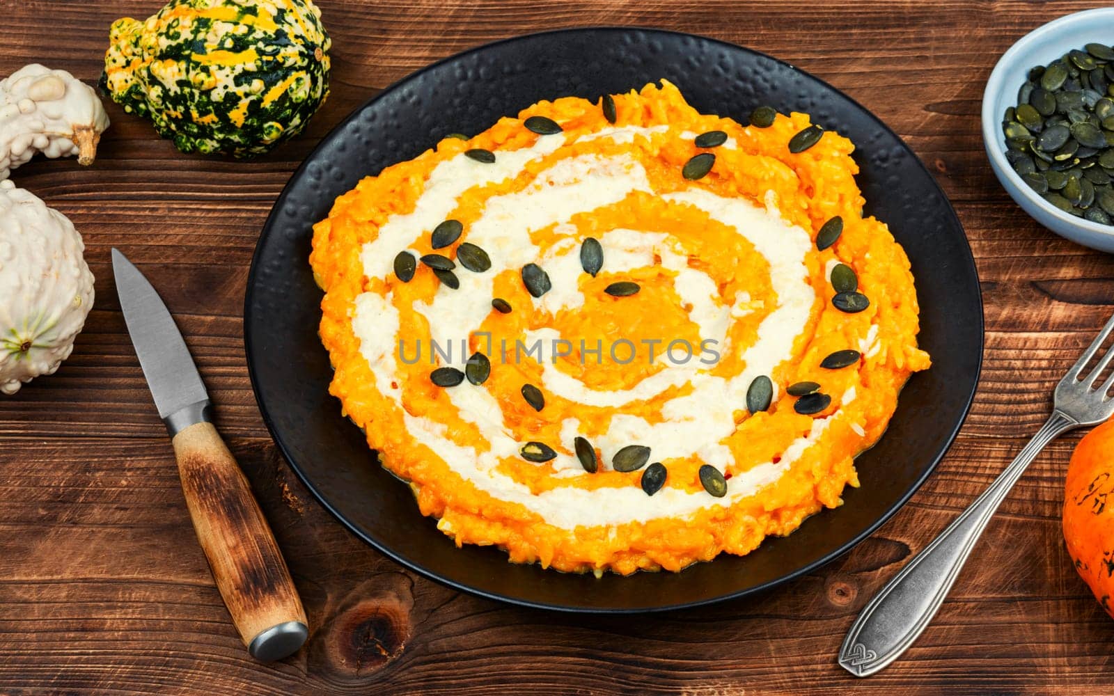 A colorful pumpkin risotto with pumpkin puree and parmesan cheese.