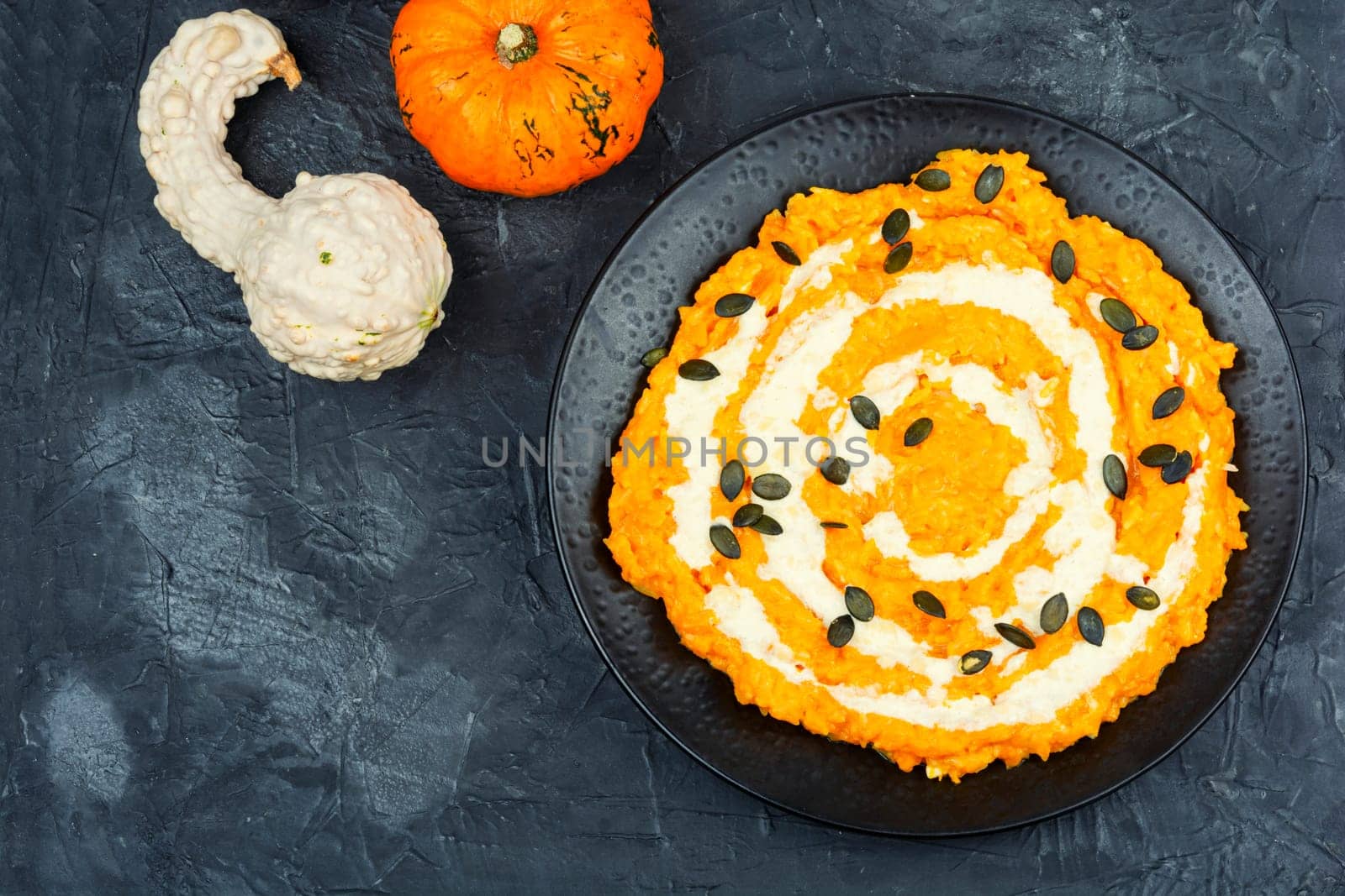 A colorful pumpkin risotto with pumpkin puree and parmesan cheese.