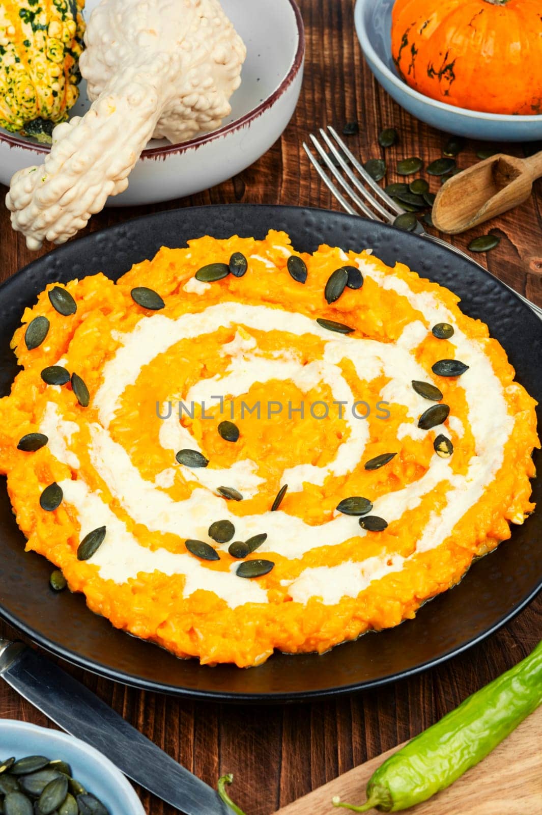 A colorful pumpkin risotto with pumpkin puree and parmesan cheese.