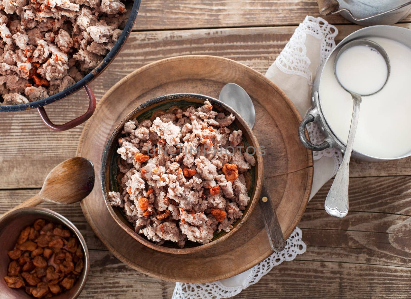 Slovenian traditional dish buckwheat mush served with pan-fried pork cracklings and lard and bowl warm milk close up shoot