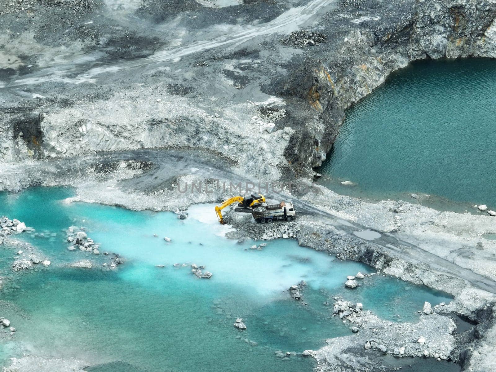Open pit mine industry. Limestone quarry with backhoe and truck in operation. Heavy machinery in mining industry and construction material supply. Landscape of resource extraction in a industrial site