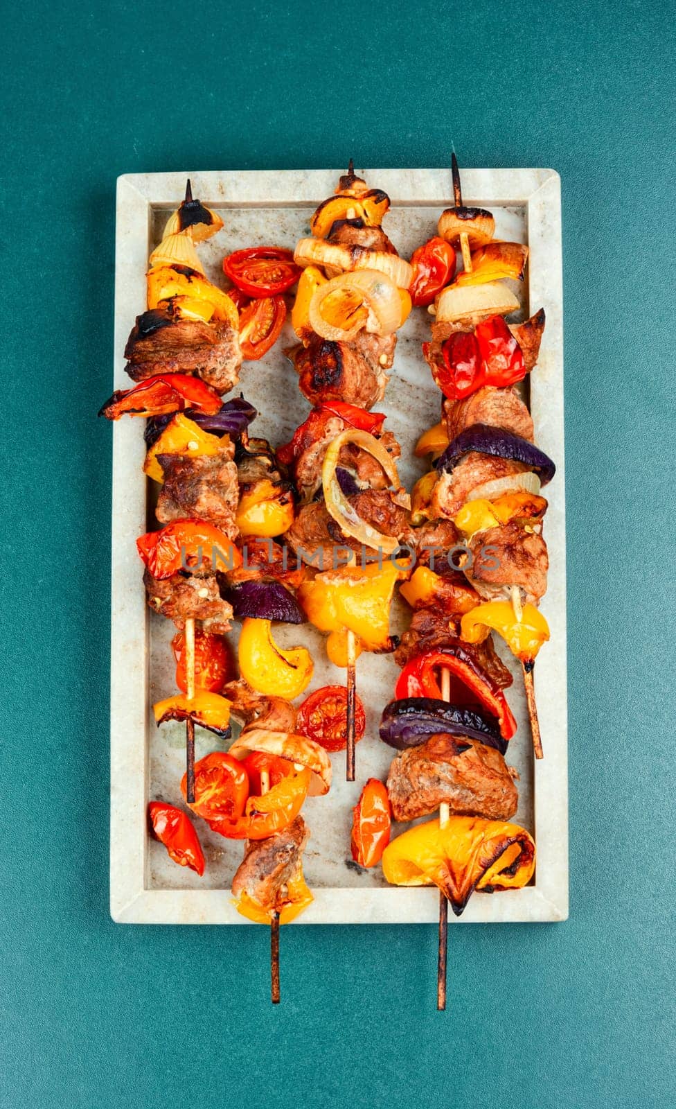 Meat kebabs with vegetables, shish kebab BBQ meat with onions. Top view with copy space.