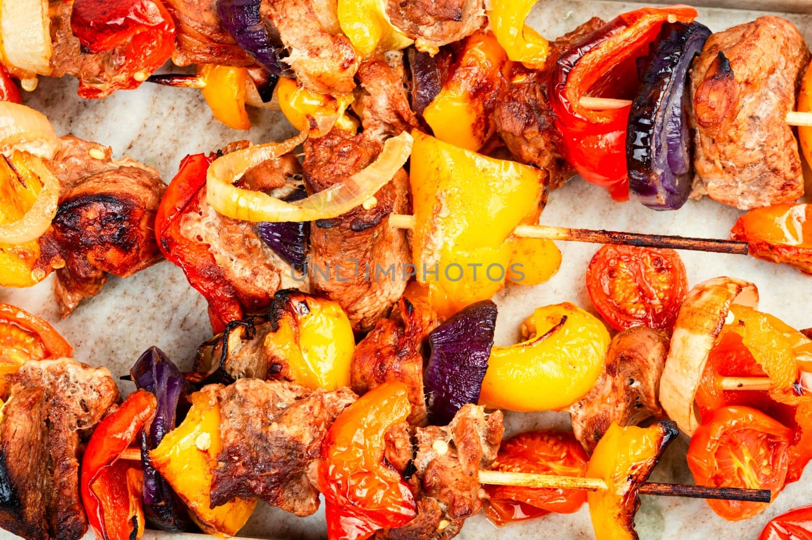 Meat kebabs with vegetables, shish kebab BBQ meat with onions. Top view with copy space.