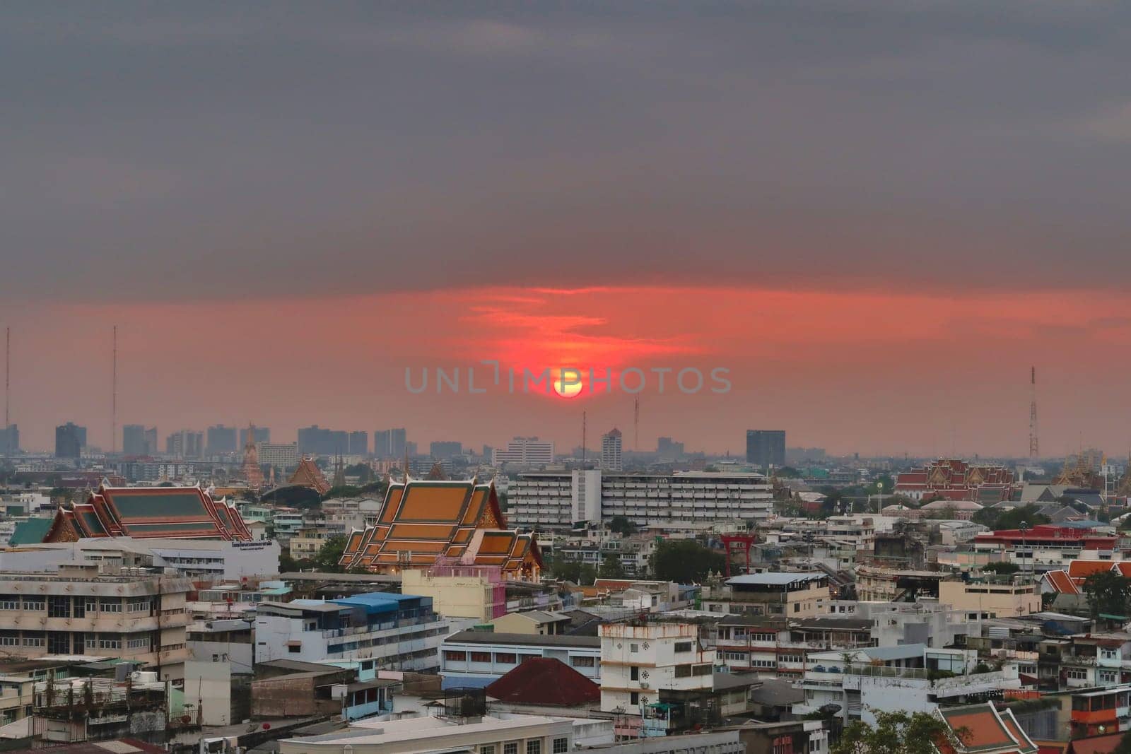 Colorful sunset over the skyline, cityscape of Bangkok, temples in the foreground and skyscrapers in the background, Thailand 2023
