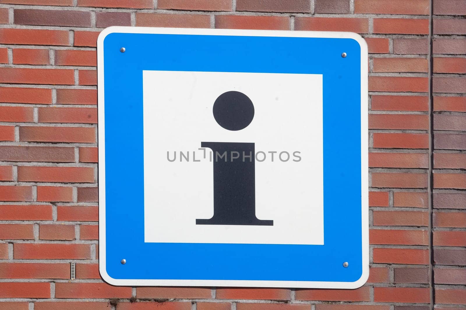 Sign Information I from a tourist information center on a reddish brick wall, Germany