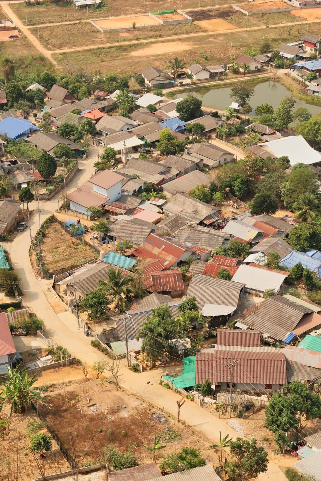 Picturesque view from the Guan Yin Statue onto a neighborhood of a traditional, rural village right next to it, Wat Huay Pla Kang Temple Complex, Chiang Rai, Thailand 2023