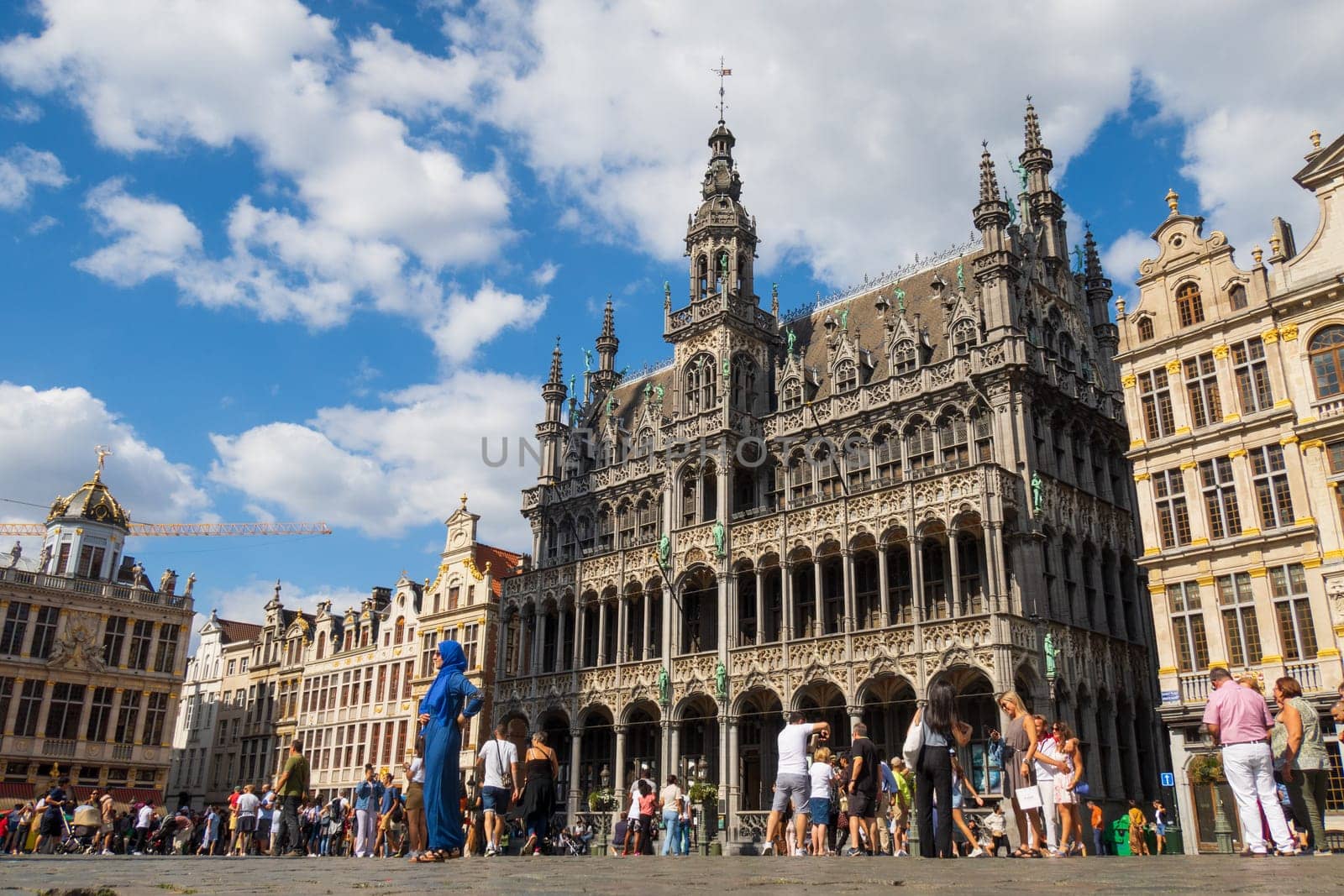Brussels, Belgium - August 20 2022 : Tourists discovering the famous Grand Place and the historical buildings in Brussels. Photography taken in Belgium