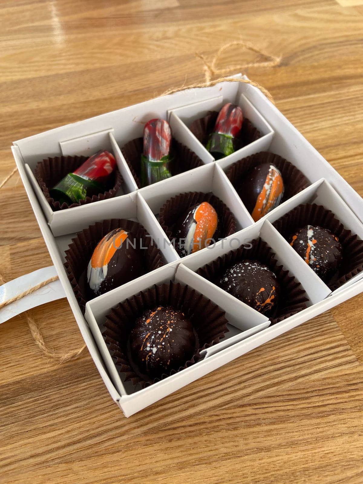 Box of artisanal chocolates vibrant, artistic designs for chocolate enthusiasts. Luxury of gourmet confections. Artistic expression in food and gourmet experience concept.