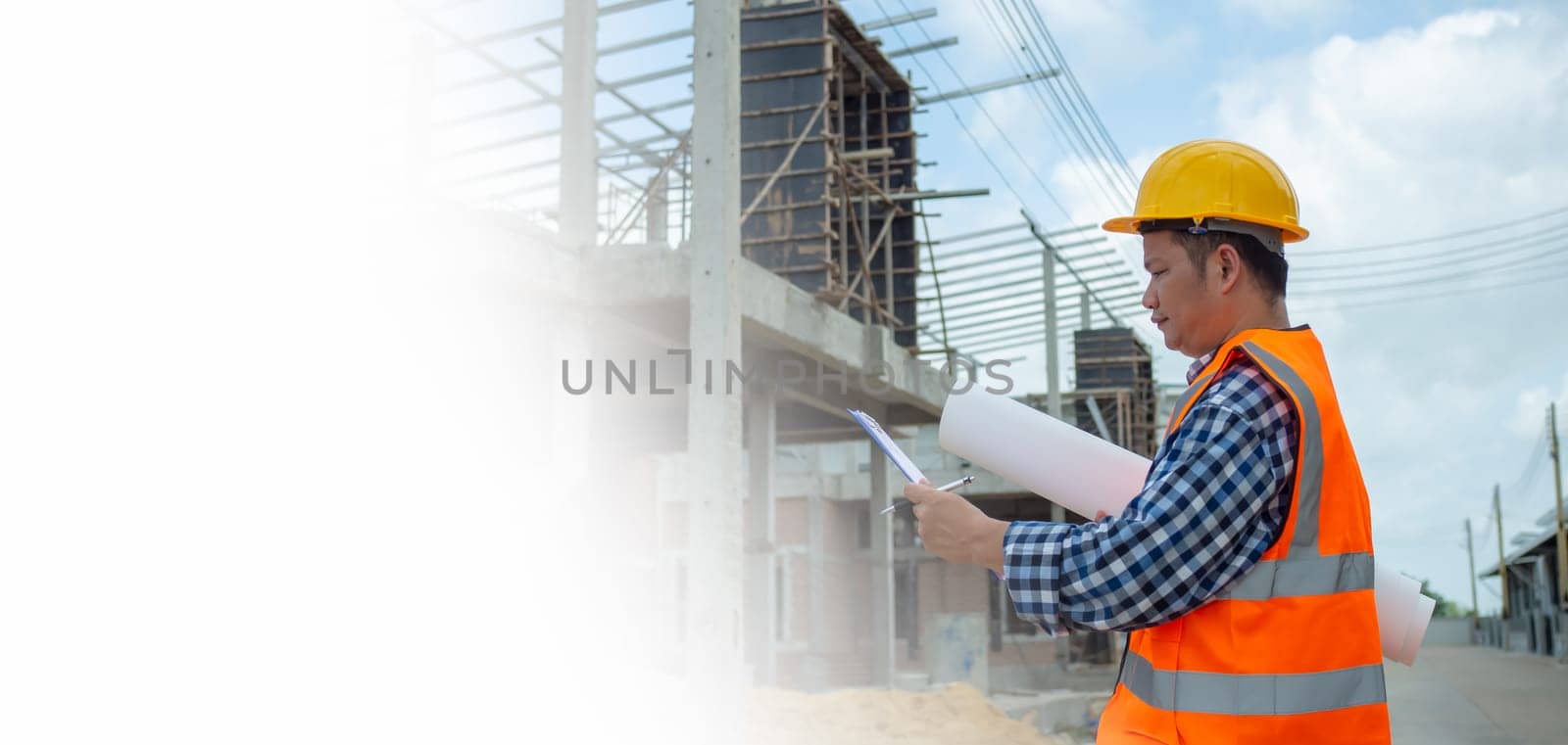 Engineers holding blueprint project working outdoors building side with blueprints on a worksite, Engineering and architecture concept, Engineer working at site of a large building project.