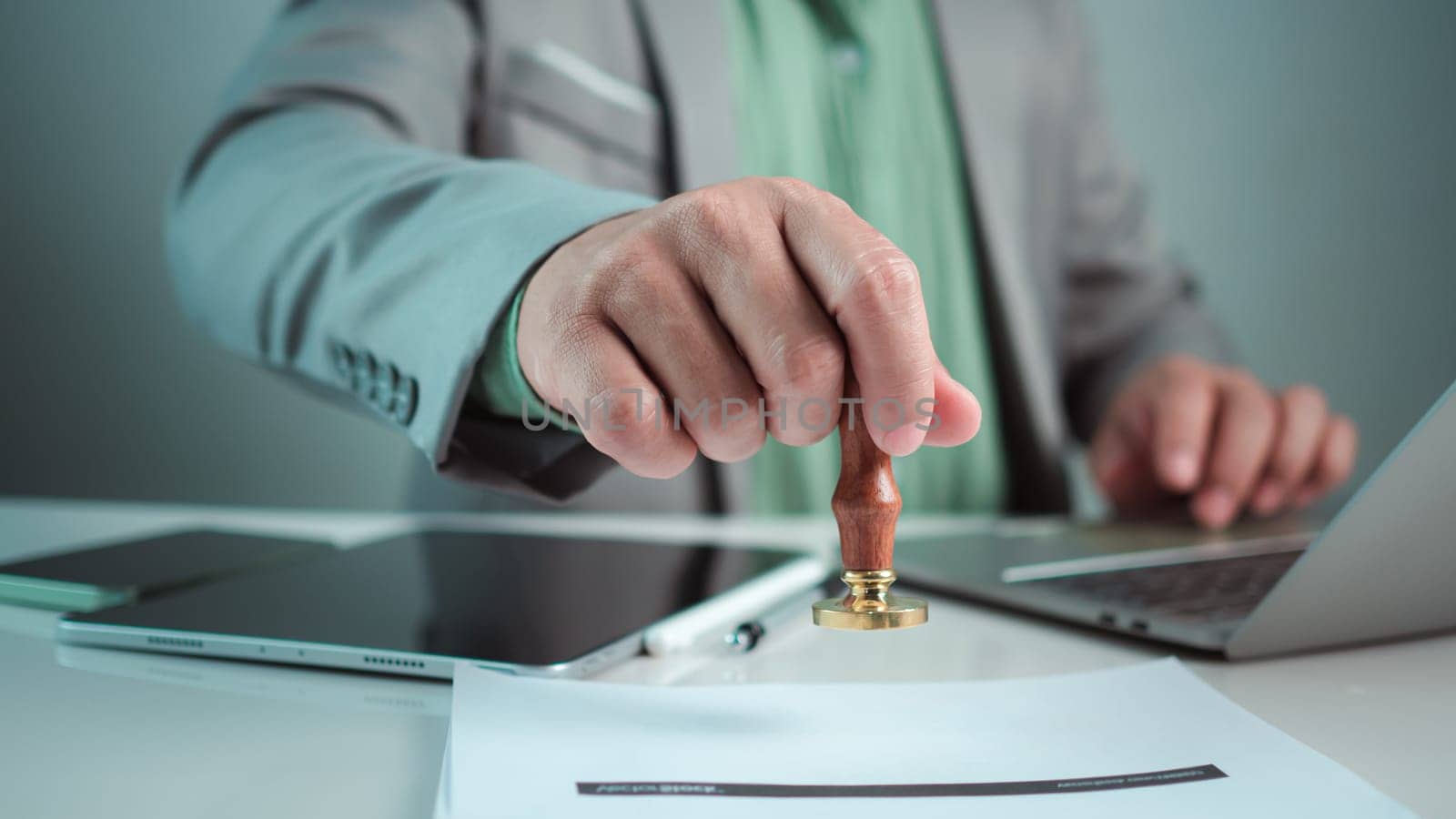 Businessman hand stamping with approved stamp on text approved document at desk, Validates and manages business documents and agreements, Approval stamp, Signing on business partner paper to success.