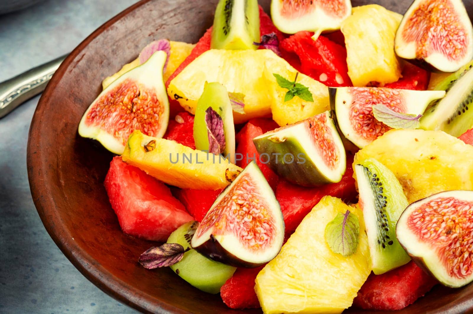 Fruit salad with pineapple, watermelon, kiwi and figs.
