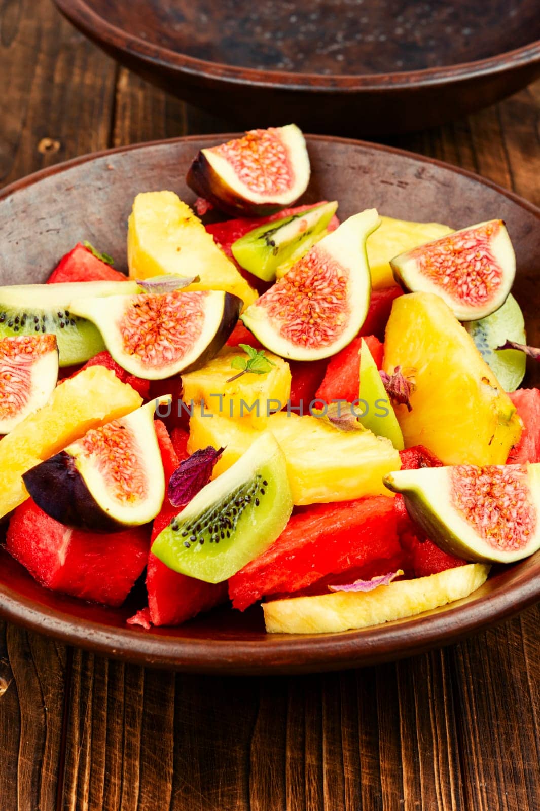 Fruit salad with pineapple, watermelon, kiwi and figs.
