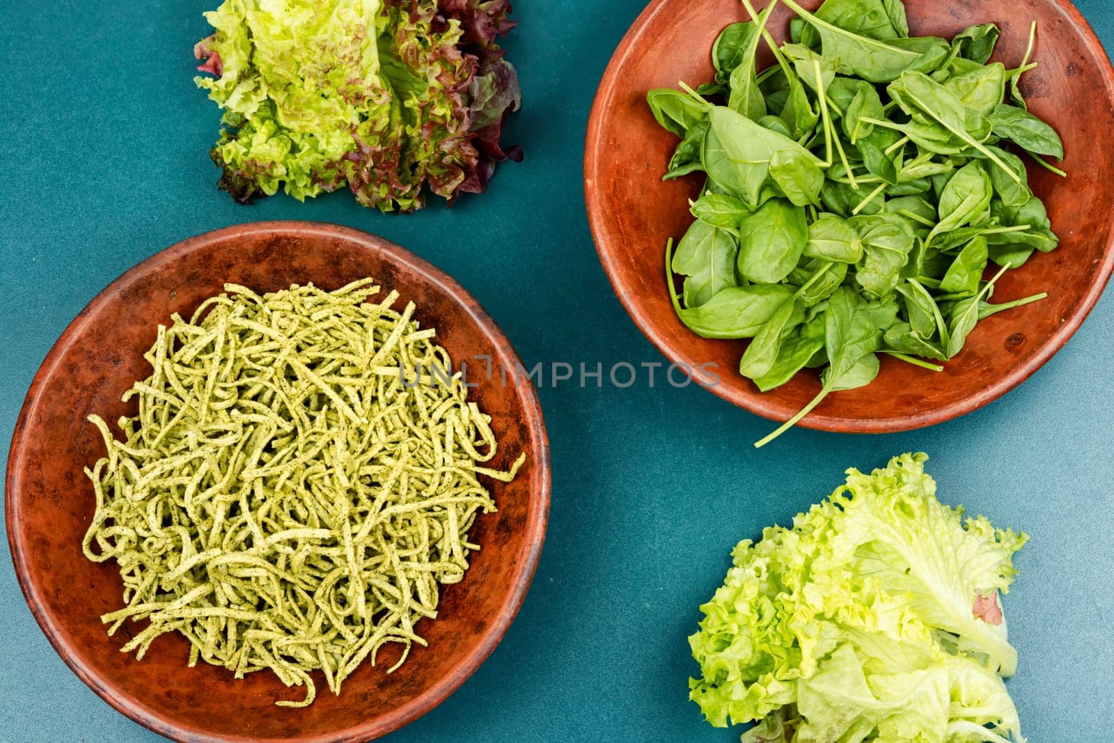 Vibrant green spinach or spinach pasta with fresh spinach leaves on wooden table. Culinary recepies, healthy food, fitness, diet.