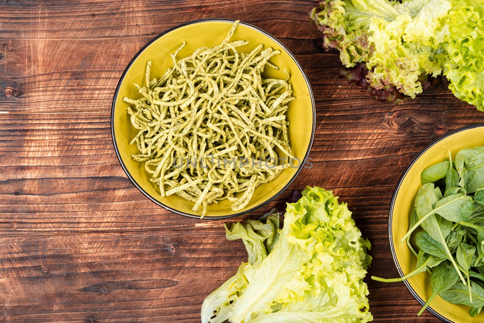 Vibrant green spinach or spinach pasta with fresh spinach leaves on wooden table. Culinary recepies, healthy food, fitness, diet.