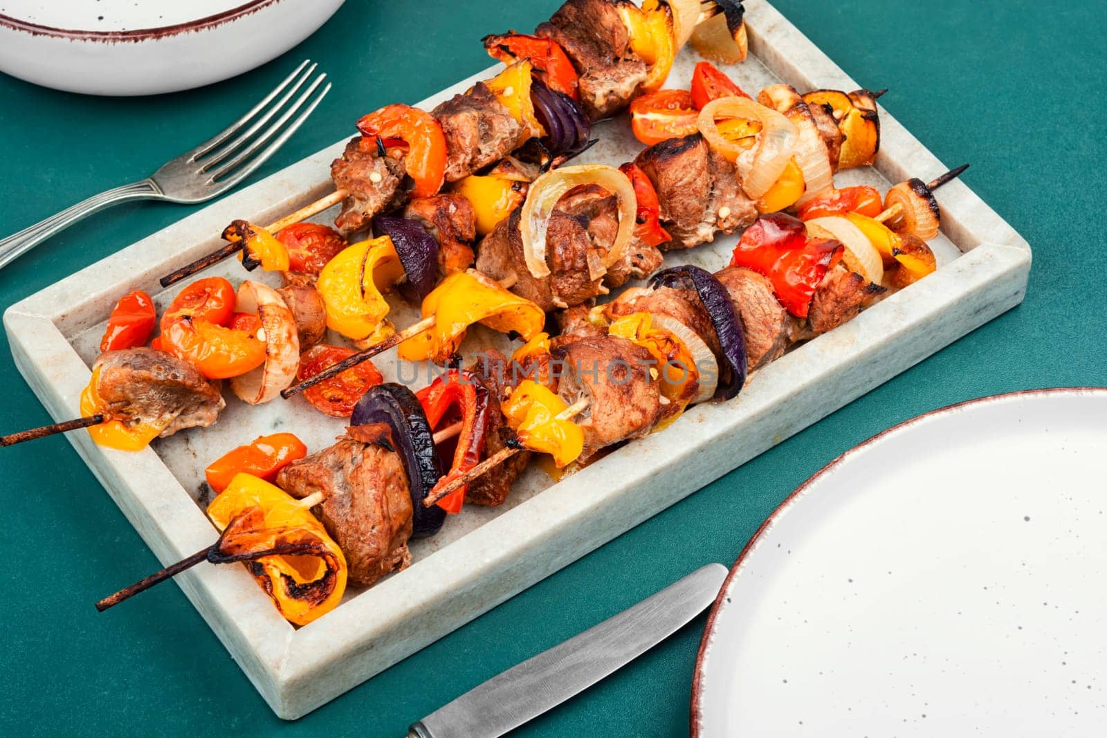 Stick BBQ grilling a variety of meats and vegetables on long thin bamboo skewers.