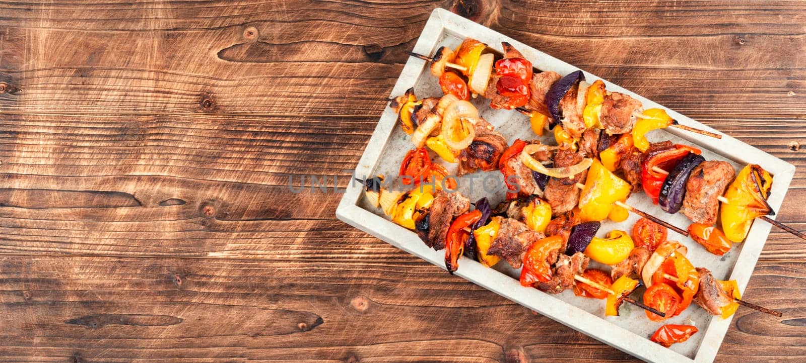 Stick BBQ grilling a variety of meats and vegetables on long thin bamboo skewers.