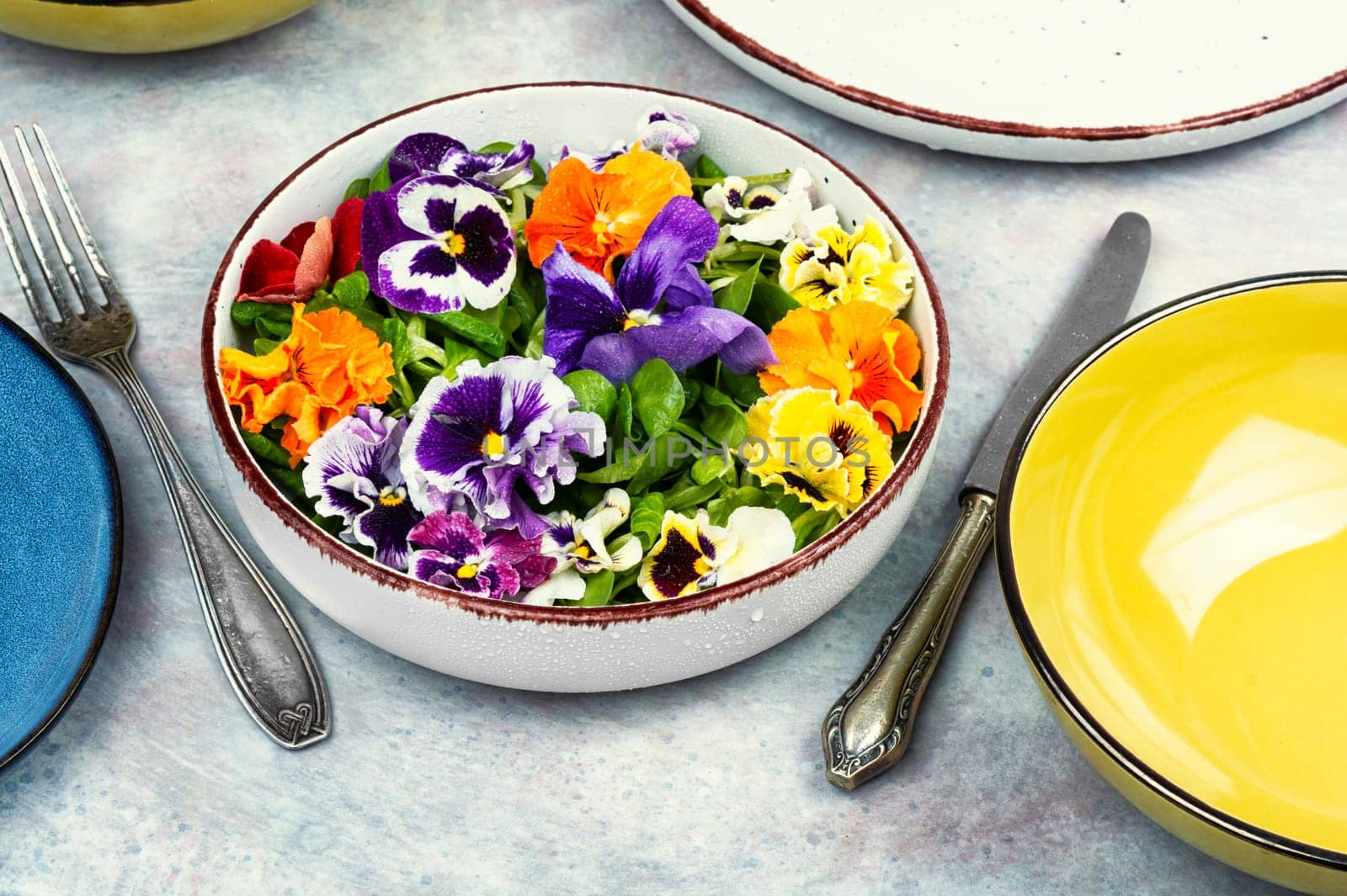 Plate of healthy summer salad with fresh ingredients and edible flowers. Clean eating concept.