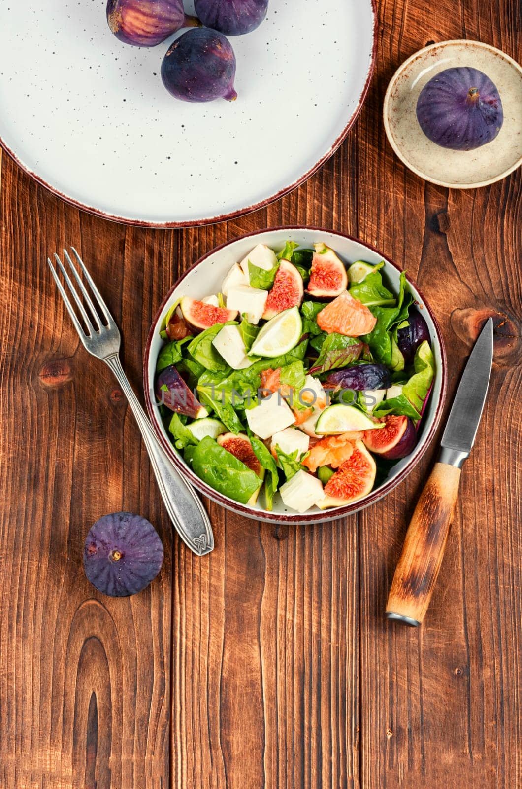 Vitamin salad with figs, greens and cheese. Close up.