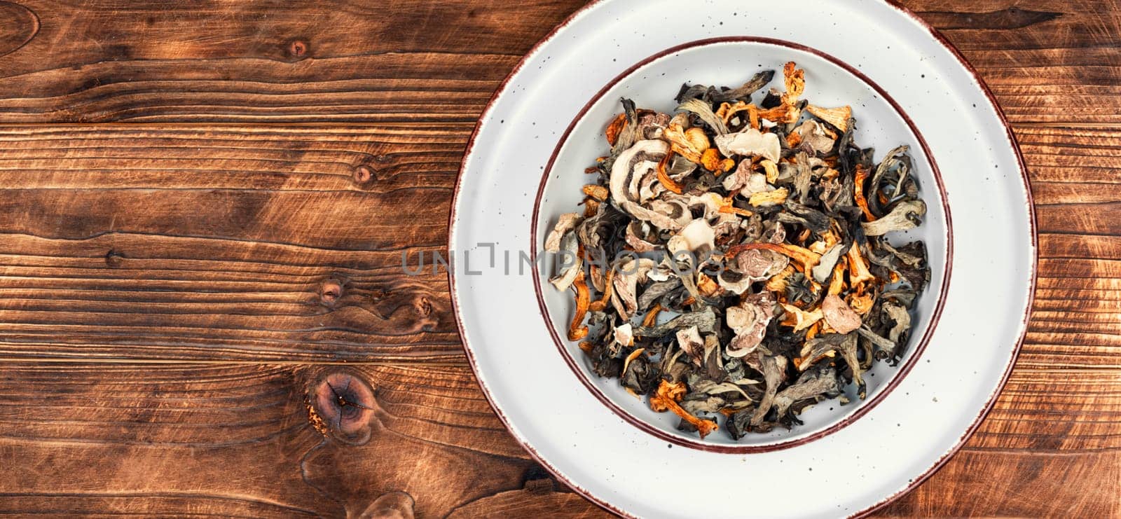 A vibrant array of dried mushrooms on a rustic wooden table. Space for text.