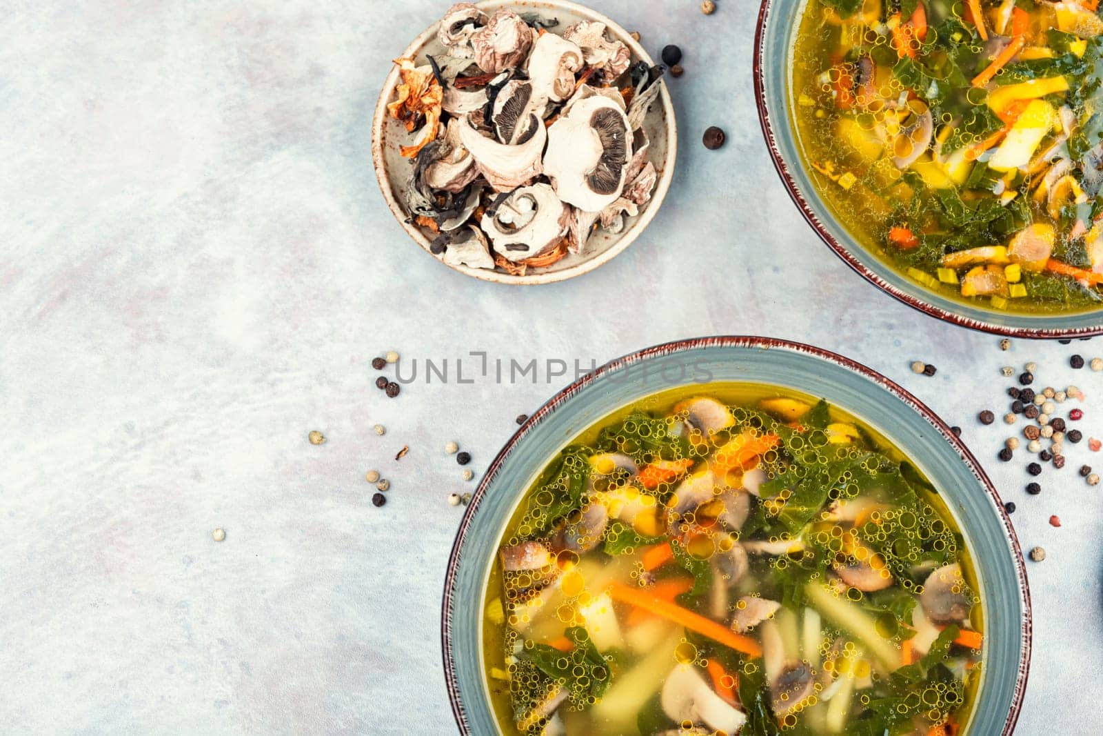 Homemade thick vegetarian mushroom soup with spinach and vegetables in a ceramic bowl. Copy space.