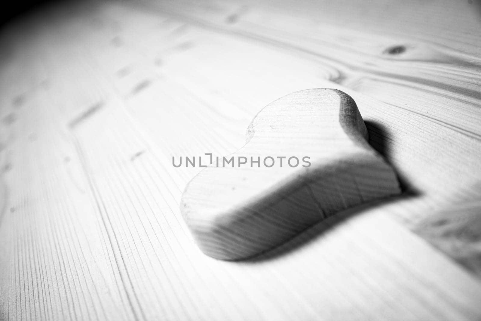 Carved wooden heart is lying on a workbench in a carpentry workshop, suggesting craftsmanship and love. - black n white -