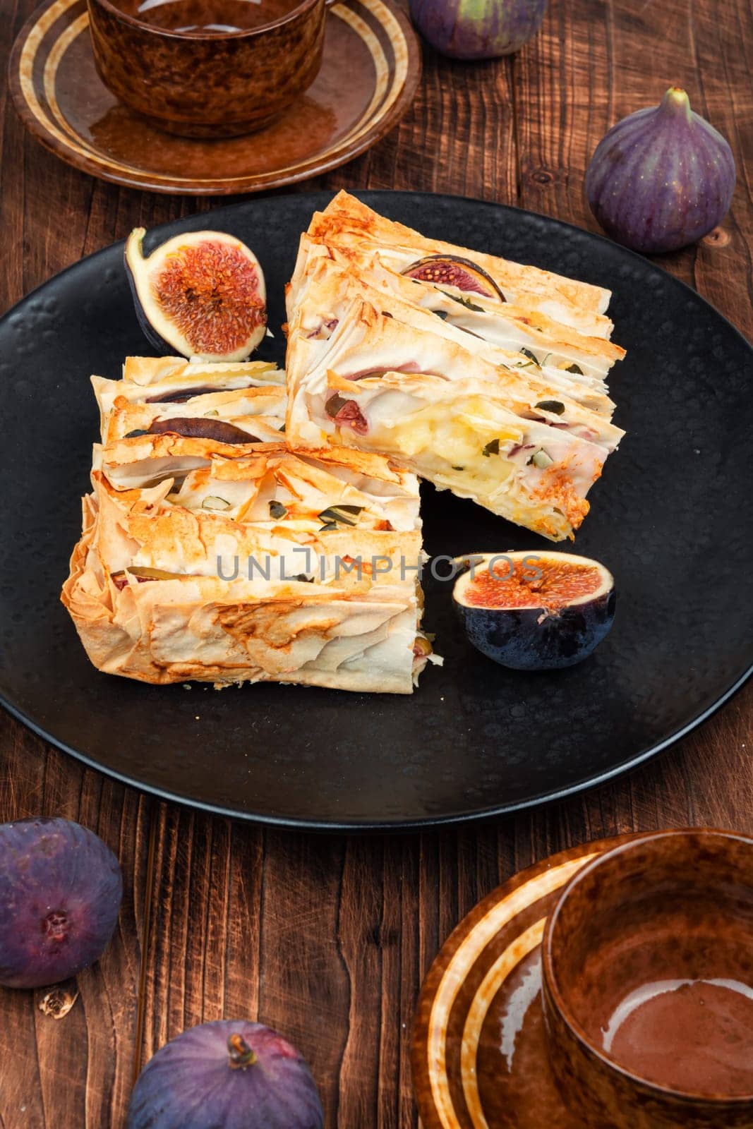Figs pie with fila dough and figs on a plate on the table. Fall fruit dessert recipe.