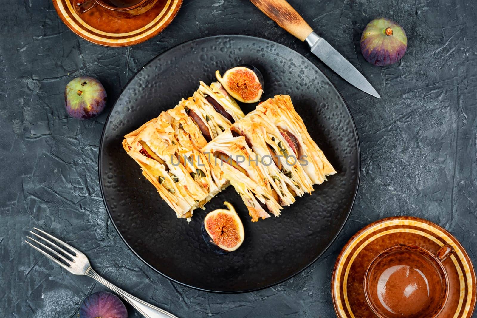 Figs pie with fila dough and figs on a plate on the table. Fall fruit dessert recipe.