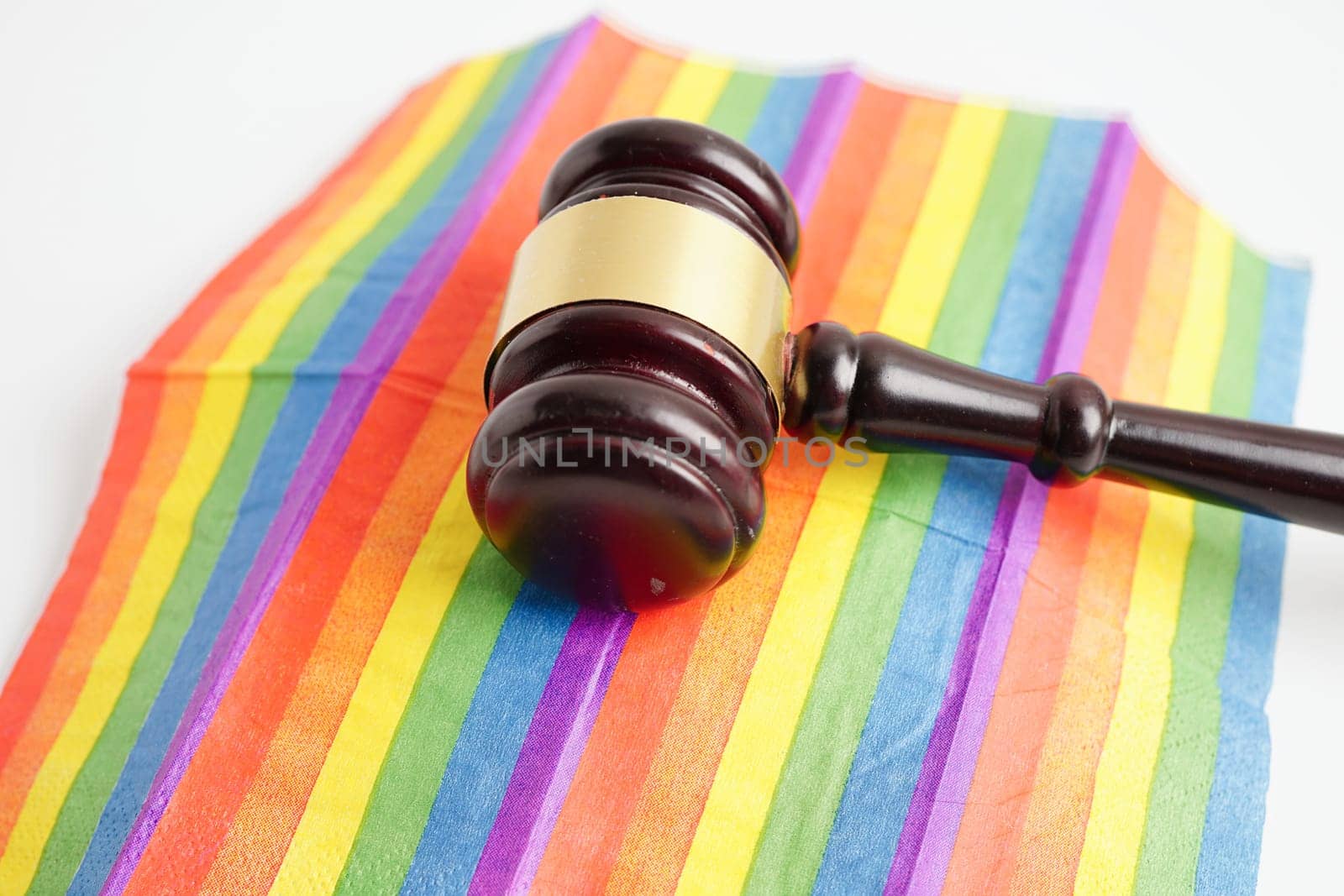 Gavel for judge lawyer on rainbow flag, symbol of LGBT pride month.