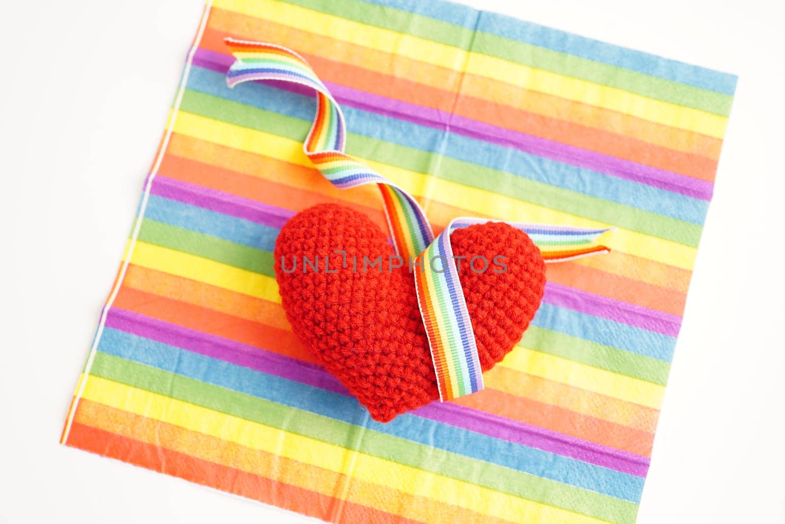 Red heart with rainbow color ribbon flag isolated on white background with clipping path, LGBT symbol.