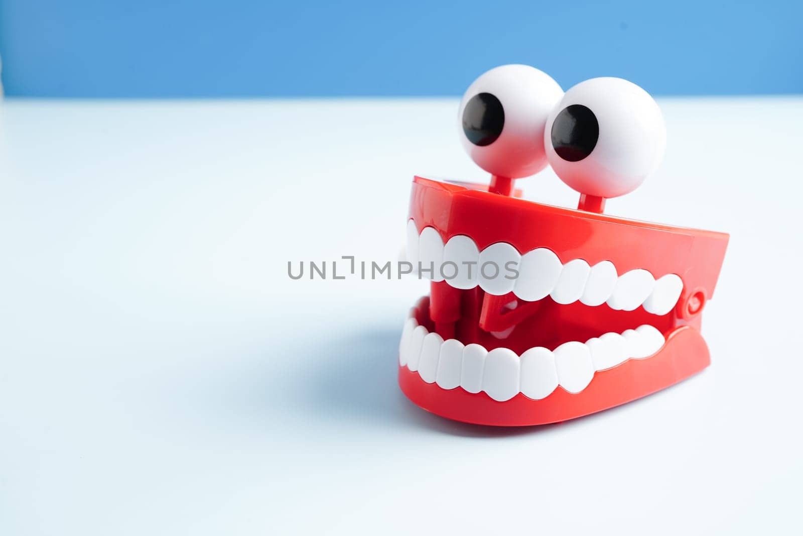 Funny red teeth with eye toy denture model for dental health care.