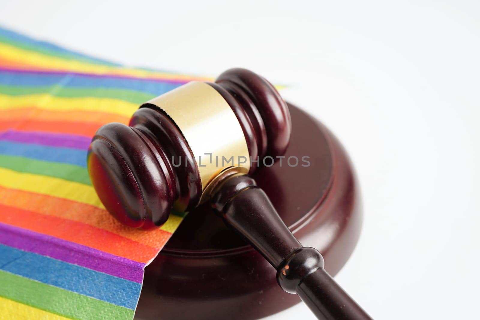 Gavel for judge lawyer on rainbow flag, symbol of LGBT pride month.