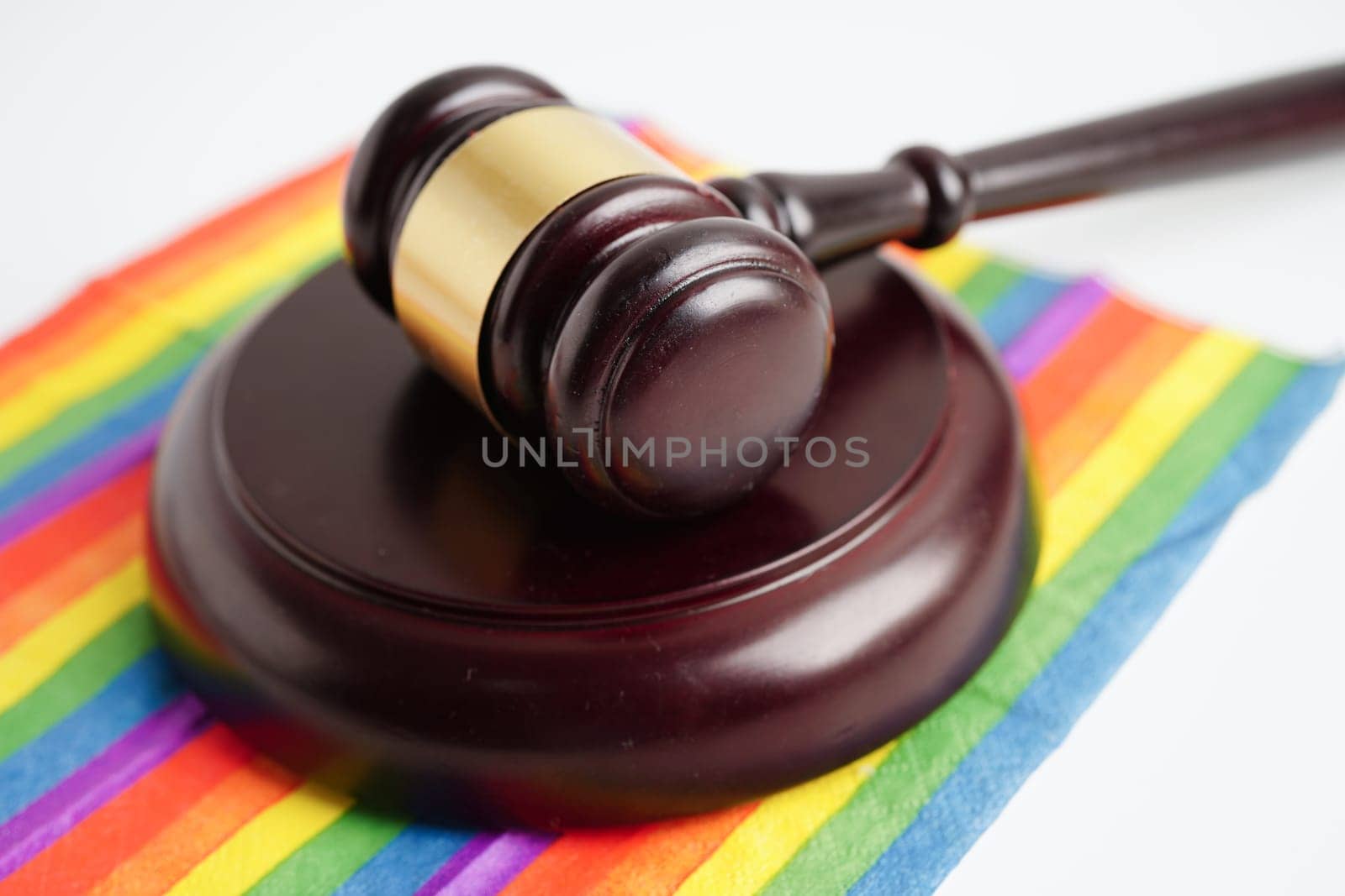 Gavel for judge lawyer on rainbow flag, symbol of LGBT pride month.