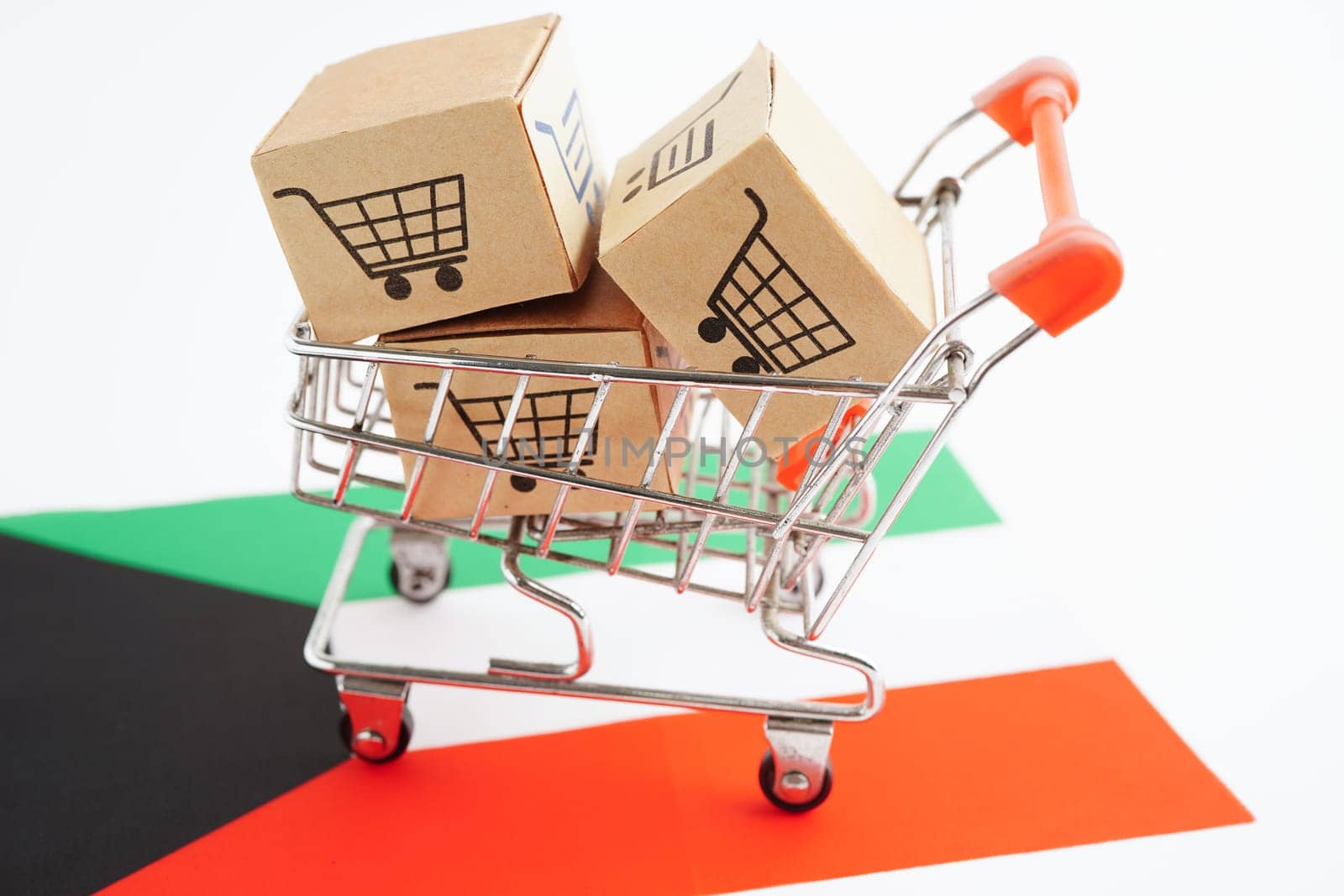 Online shopping, Shopping cart box on Kuwait flag, import export, finance commerce.