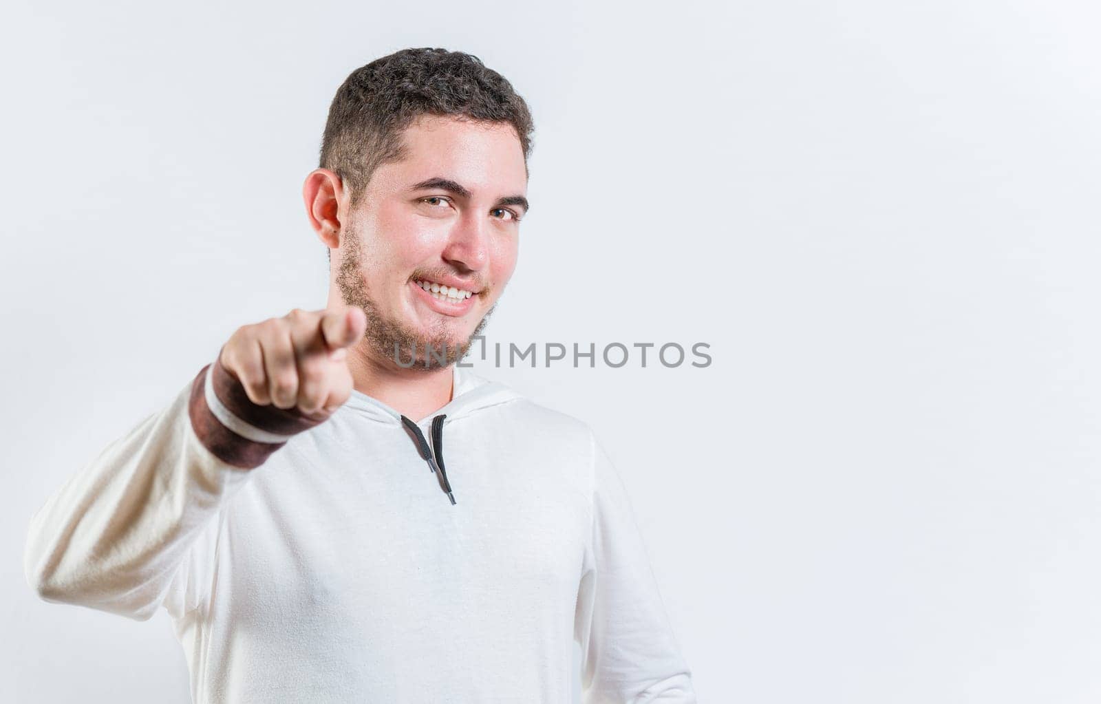 Attractive cool guy pointing at the camera isolated. Happy teenage guy pointing at you on isolated background