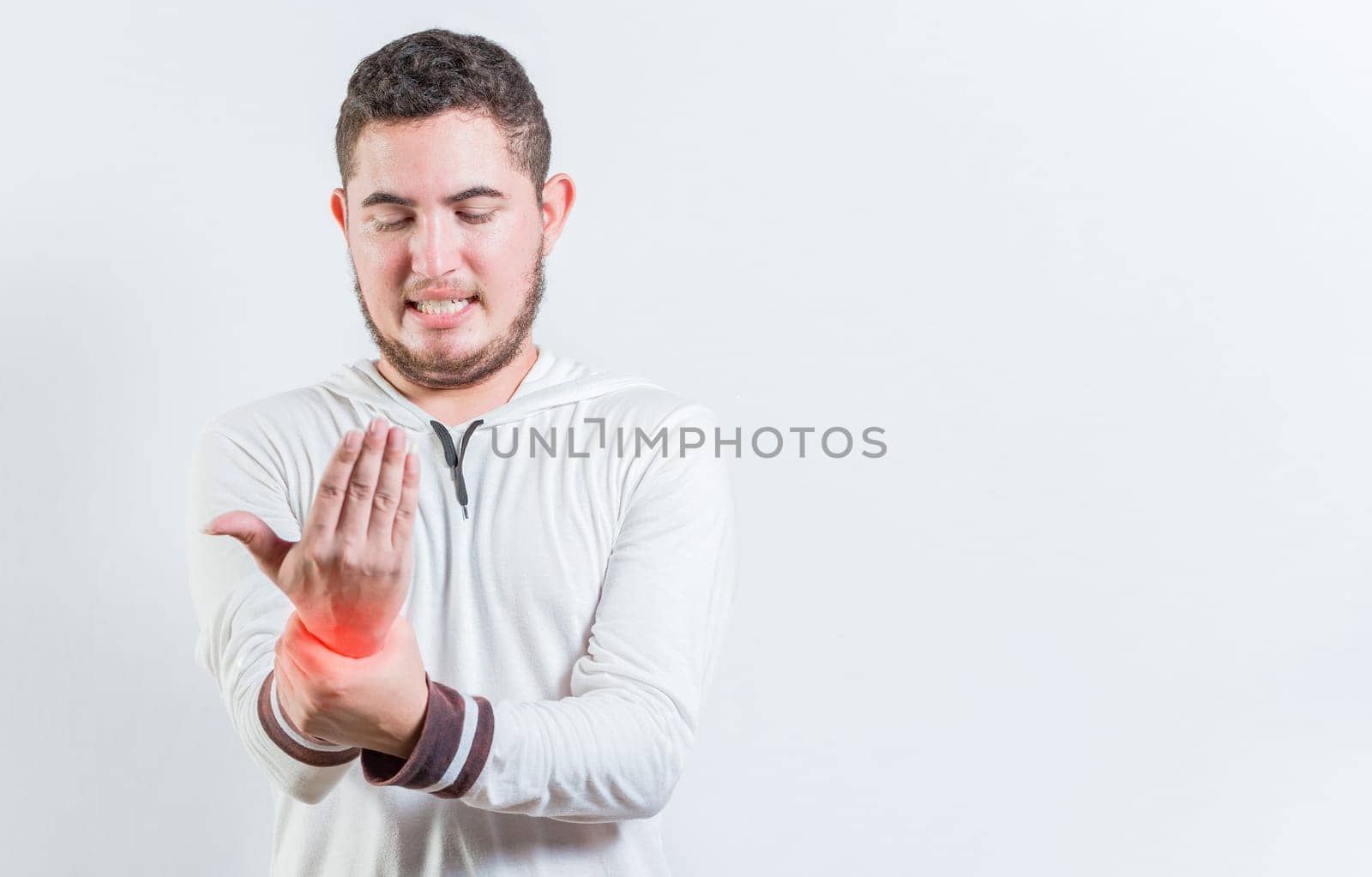 Person with arthritis pain rubbing hand isolated. Suffering young man with pain in hand joints isolated