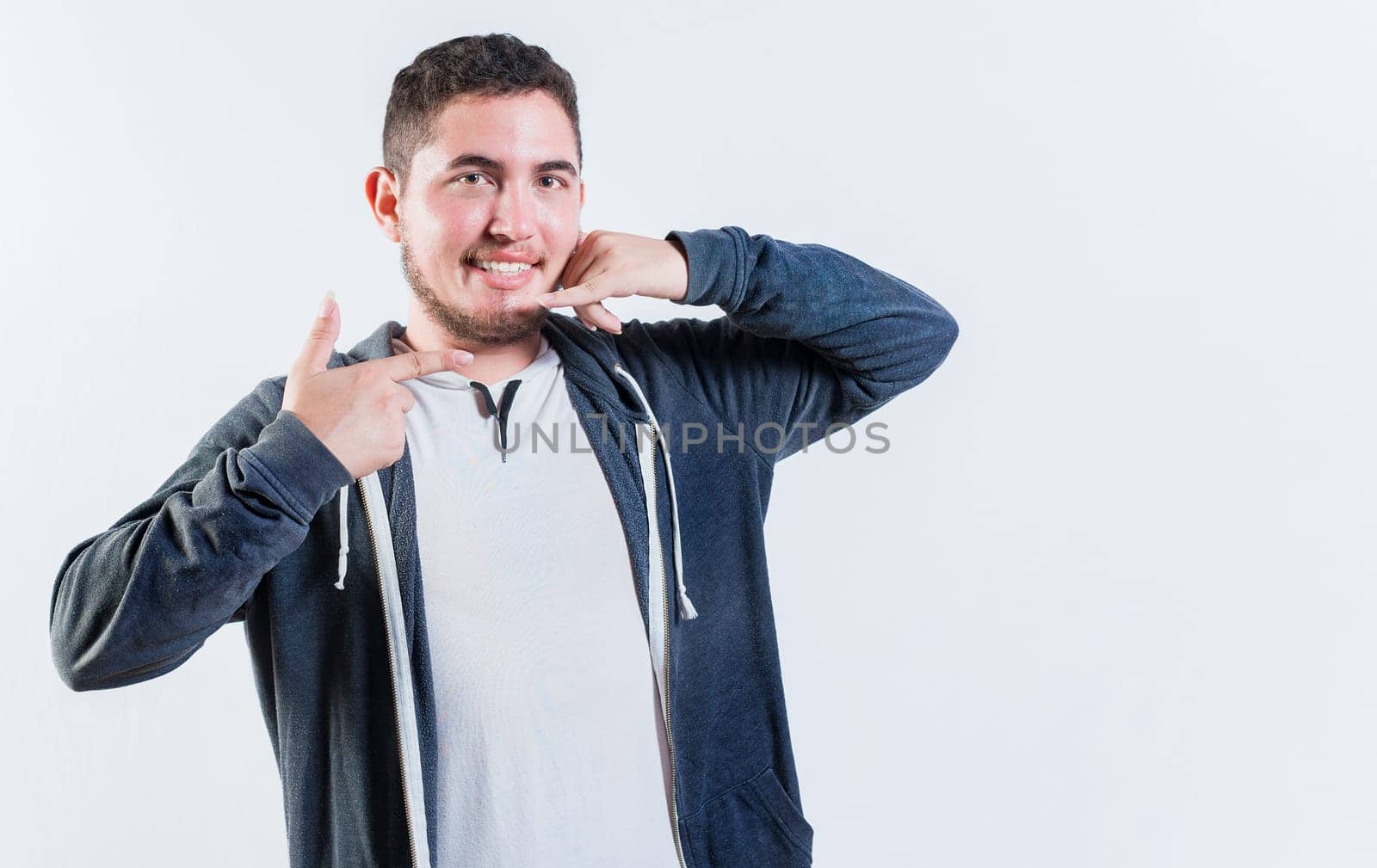 Person gesturing CALL ME in sign language isolated. Handsome young man gesturing CALL ME on isolated background