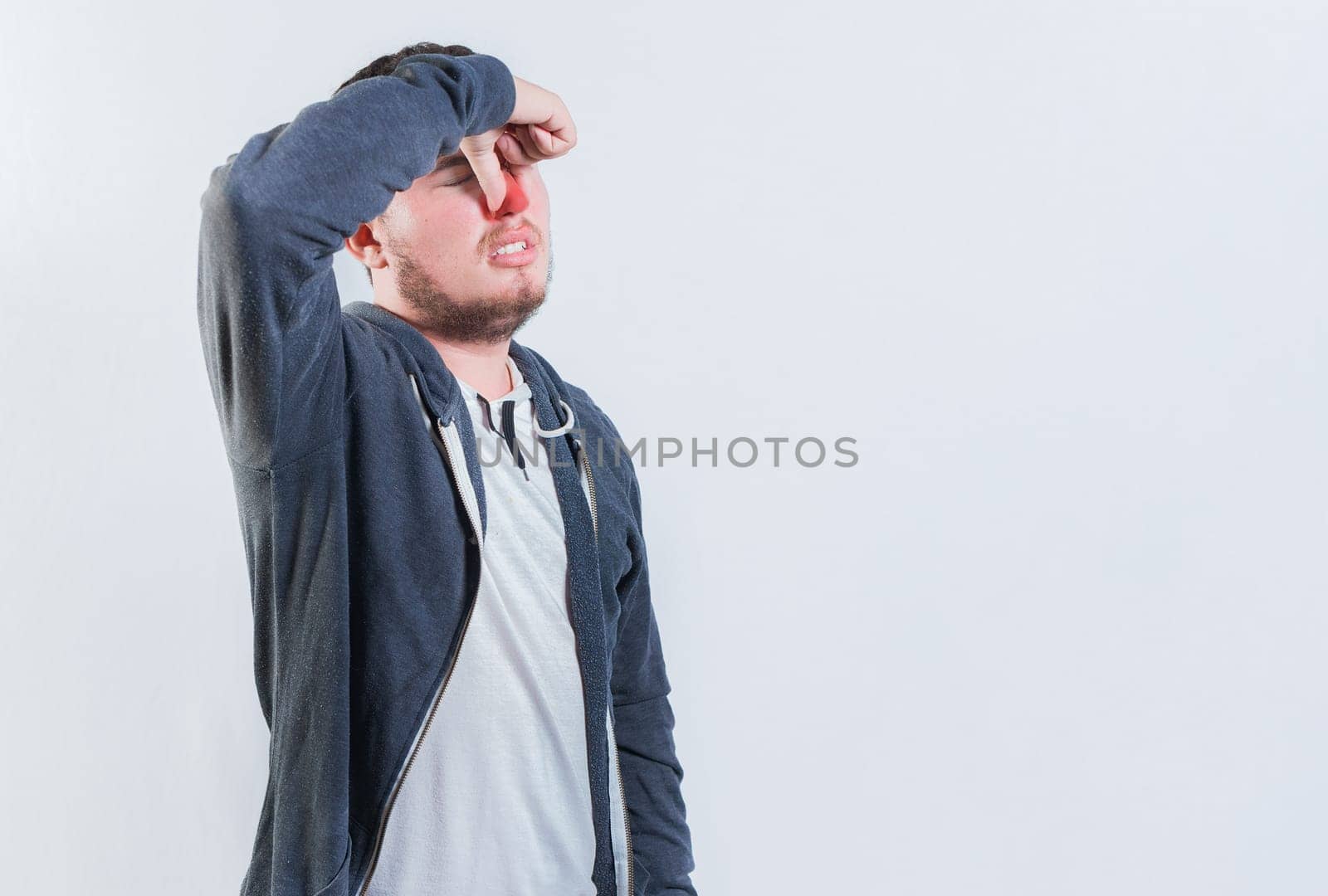 Suffering man with nasal bridge pain isolated. Guy suffering with nasal bridge on isolated background