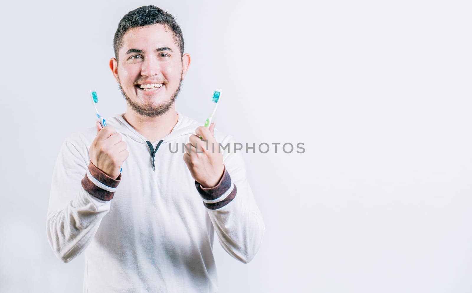Teenager holding two toothbrushes isolated. Oral health concept. Toothbrush change concept