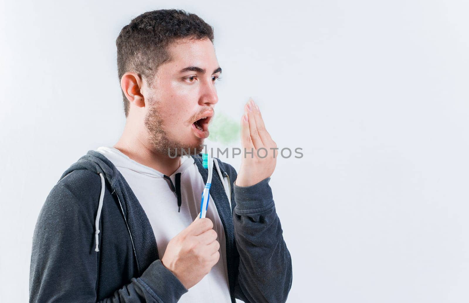 Man holding brush checking bad breath. Person holding brush with bad breath problem