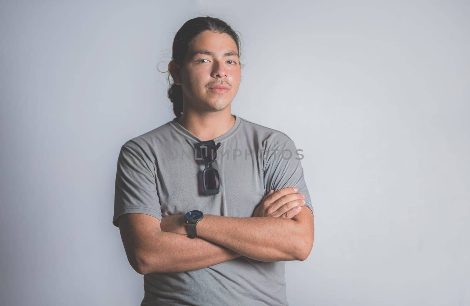 Smiling latin young man with crossed arms isolated, looking at camera