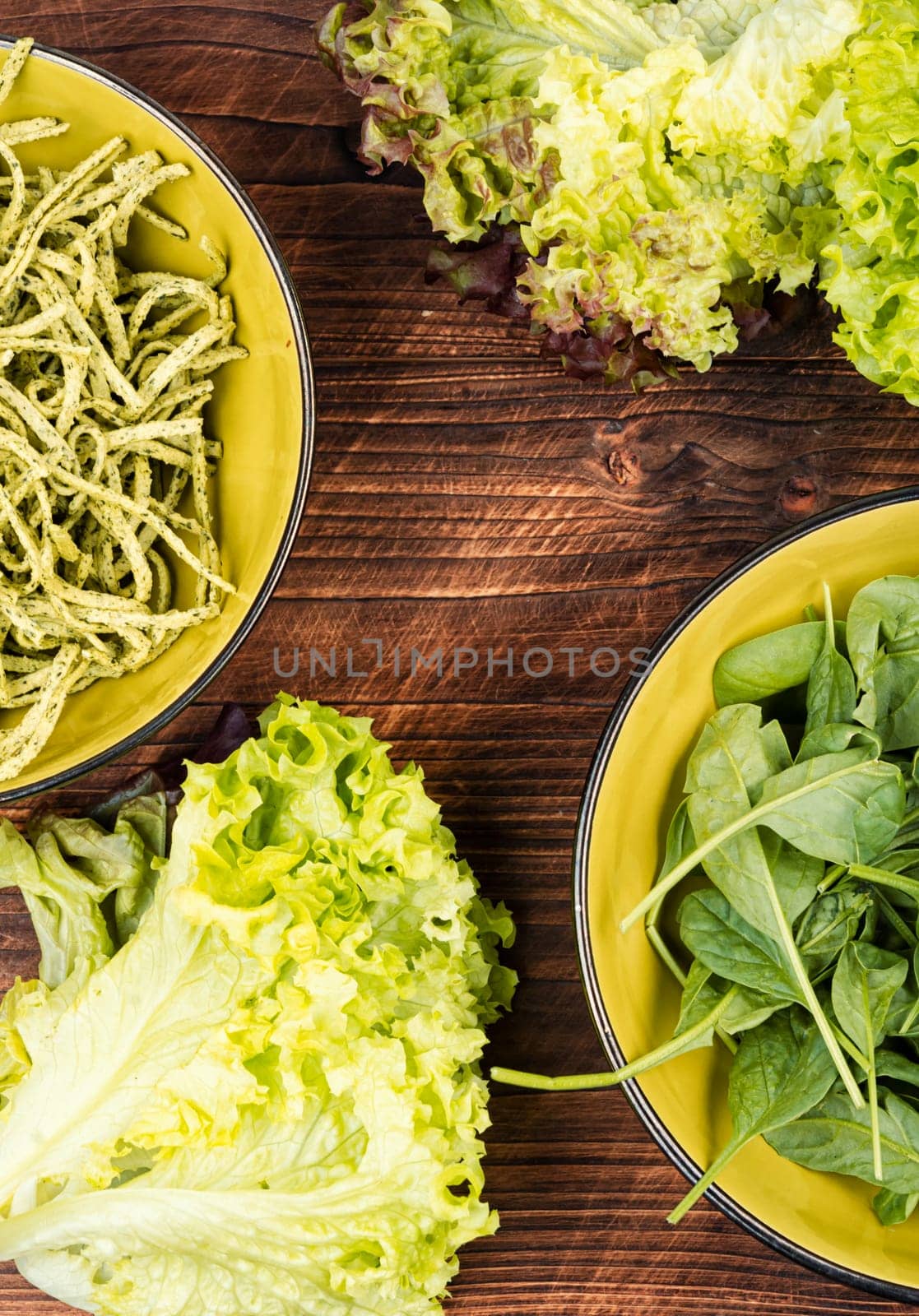 Spaghetti pasta with spinach and green on wooden table. Raw Italian food
