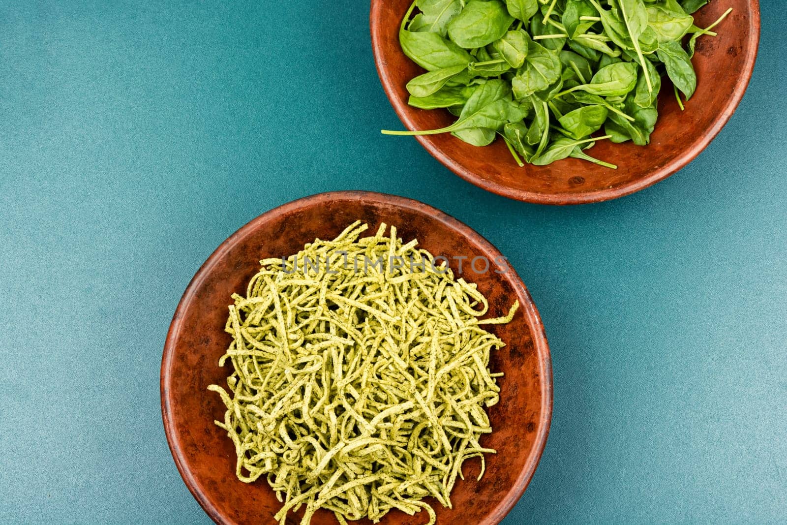 Spaghetti pasta with spinach and green on wooden table. Raw Italian food