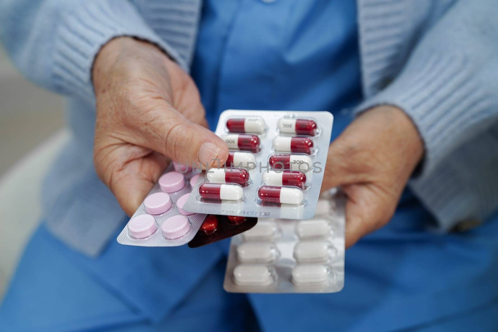 Asian elderly woman holding pill drug in hand, strong healthy medical.