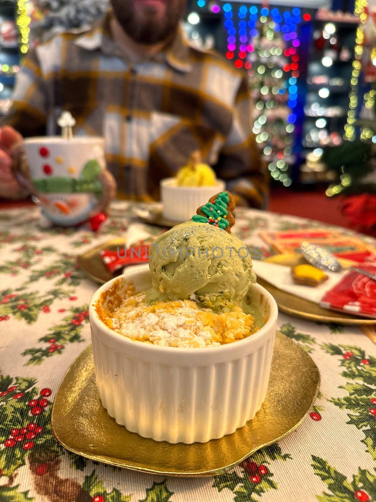 Festive dessert table with holiday-themed decorations. a warm crumble topped with a scoop of ice cream and a Christmas tree decoration captures the cozy atmosphere of a winter celebration. Festive and joyful winter celebrations. Xmas treats.