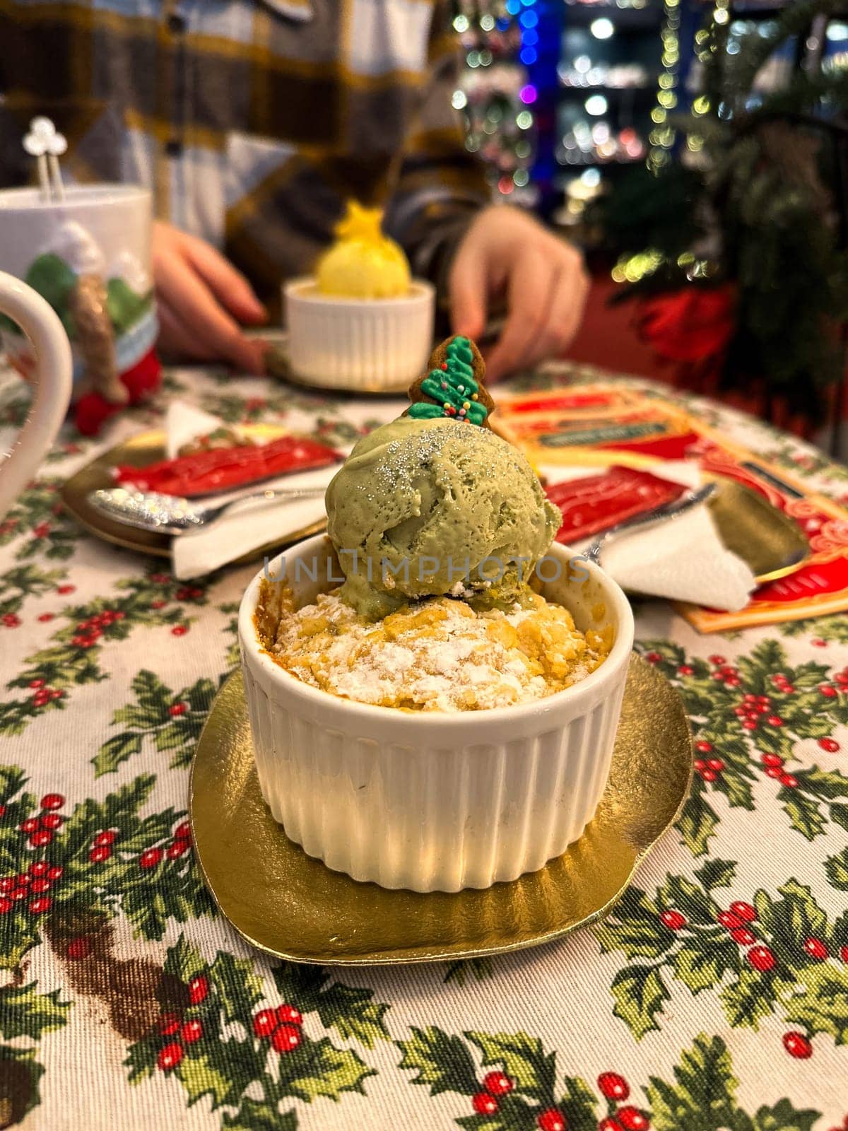 Festive dessert table with holiday-themed decorations. a warm crumble topped with a scoop of ice cream and a Christmas tree decoration captures the cozy atmosphere of a winter celebration. Festive and joyful winter celebrations. Xmas treats.