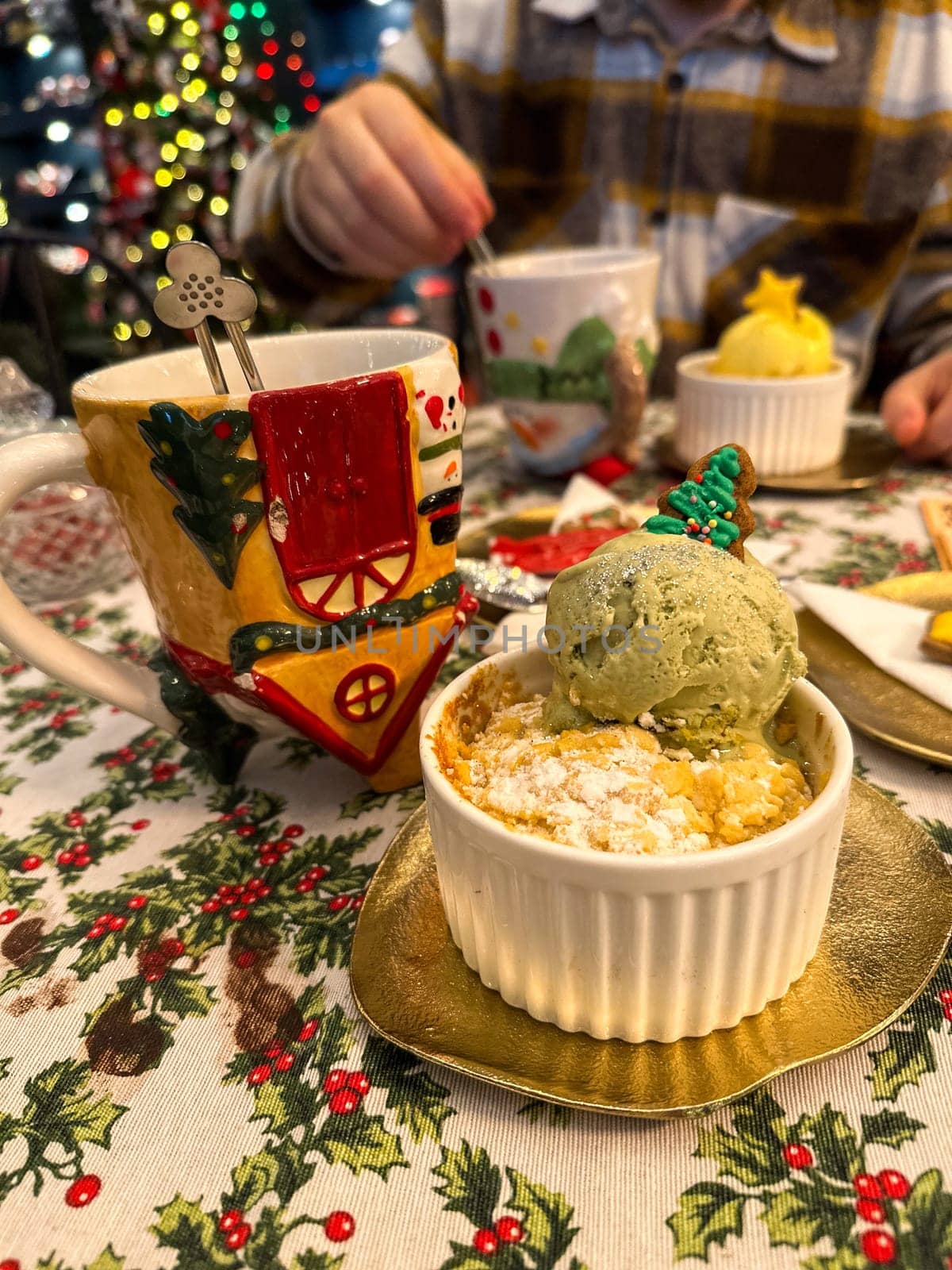 Festive dessert table with holiday-themed decorations. a warm crumble topped with a scoop of ice cream and a Christmas tree decoration captures the cozy atmosphere of a winter celebration. Festive and joyful winter celebrations. Xmas treats.