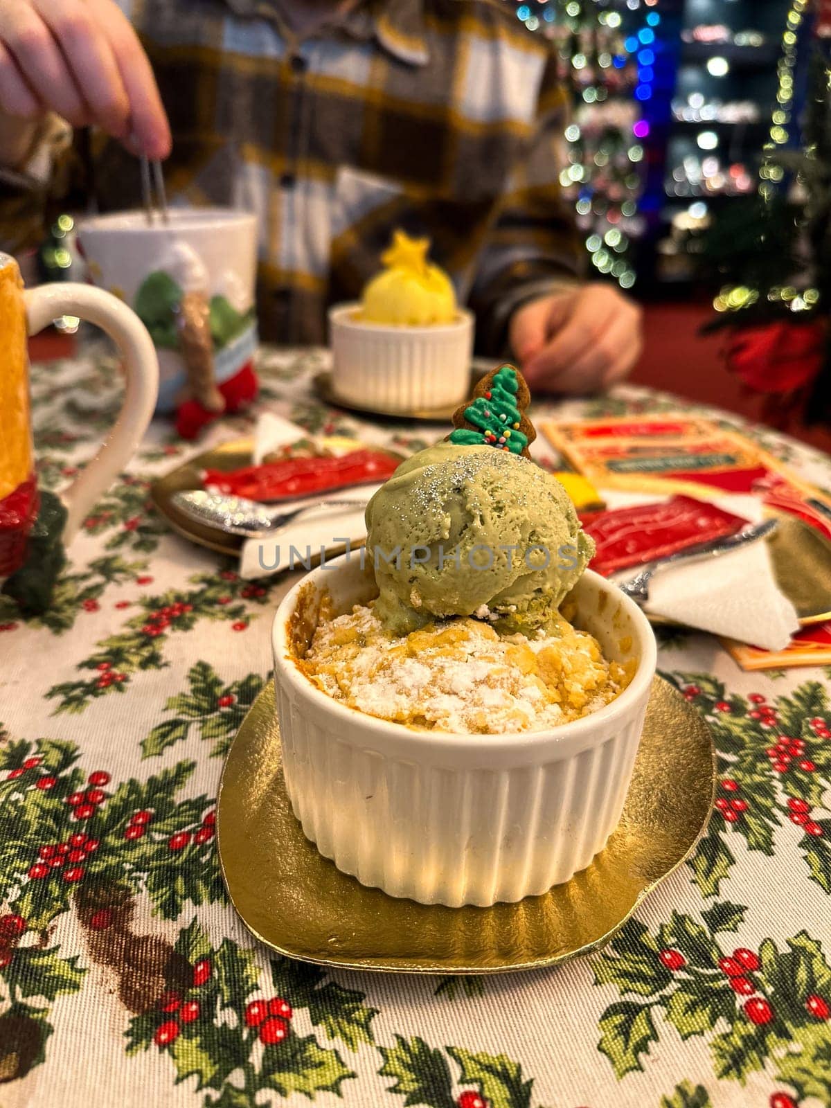 Festive dessert table with holiday-themed decorations. a warm crumble topped with a scoop of ice cream and a Christmas tree decoration captures the cozy atmosphere of a winter celebration. Festive and joyful winter celebrations. Xmas treats.