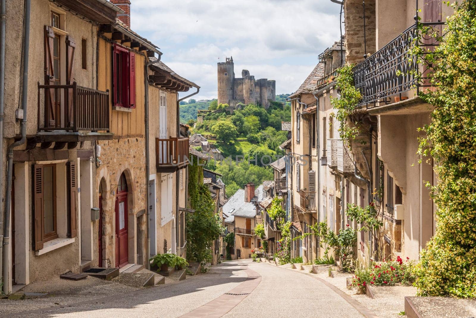 Main street in the village of Najac, one of the most beautiful villages of France, offering fantastic view over the emerging medieval castle, Aveyron, France